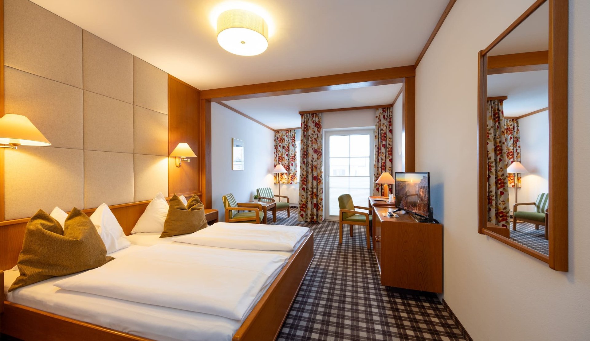 Cozily furnished double room at Hotel zum Mohren with a sitting area, desk, and balcony.