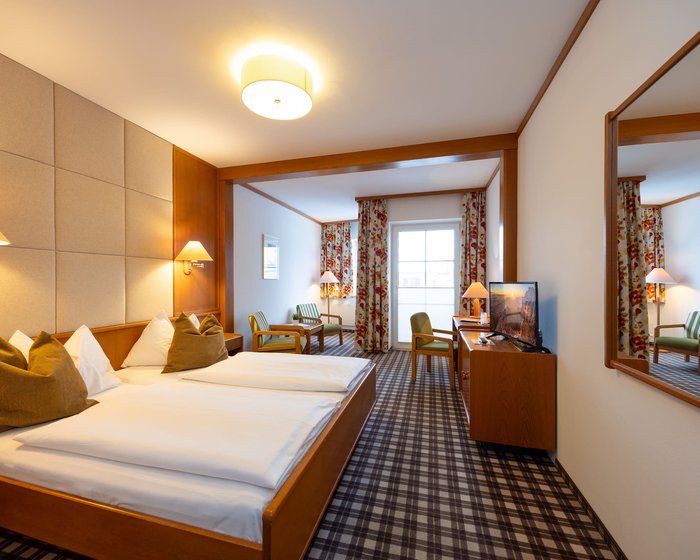 Cozily furnished double room at Hotel zum Mohren with a sitting area, desk, and balcony.