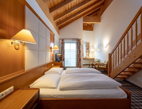 Geräumiges Maisonette-Zimmer im Hotel zum Mohren mit Holzbalkendecke und gemütlichem Doppelbett.