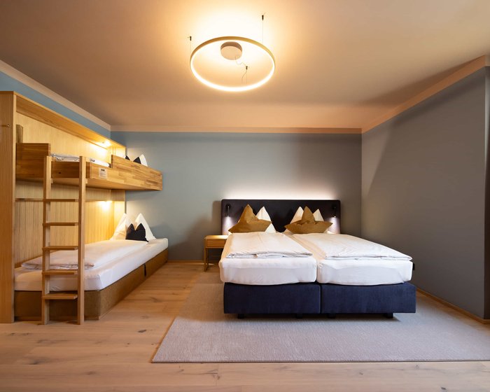 Familienzimmer Standard mit Doppelbett, Schreibtisch und Holzdetails.