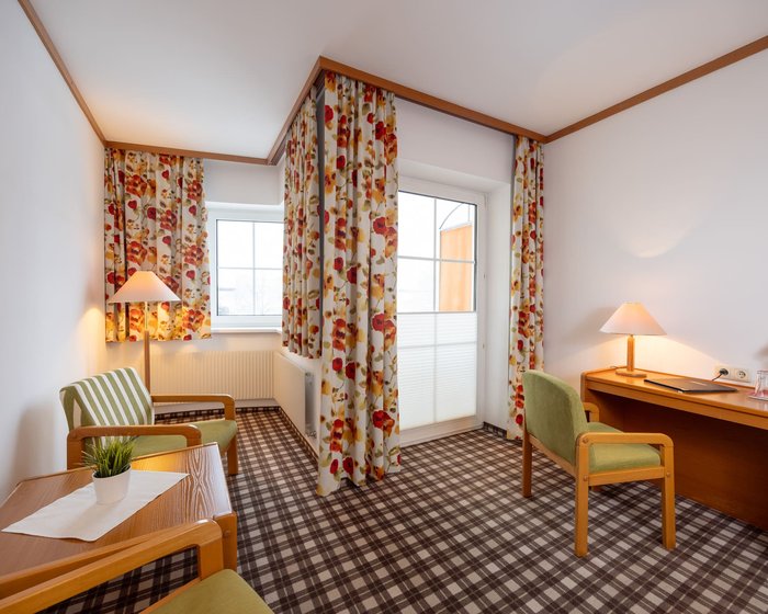 Cozily furnished double room at Hotel zum Mohren with a sitting area, desk, and balcony.
