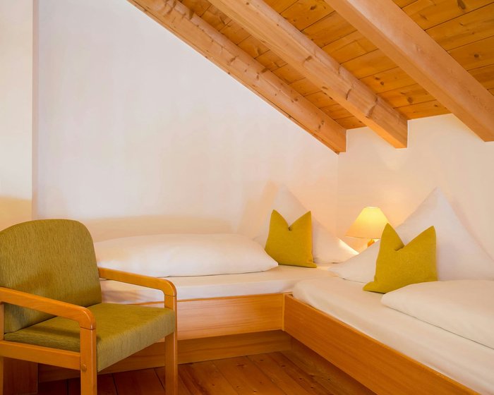 Spacious maisonette room at Hotel zum Mohren with a wooden beam ceiling and a cozy double bed.