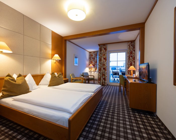 Cozily furnished double room at Hotel zum Mohren with a sitting area, desk, and balcony.