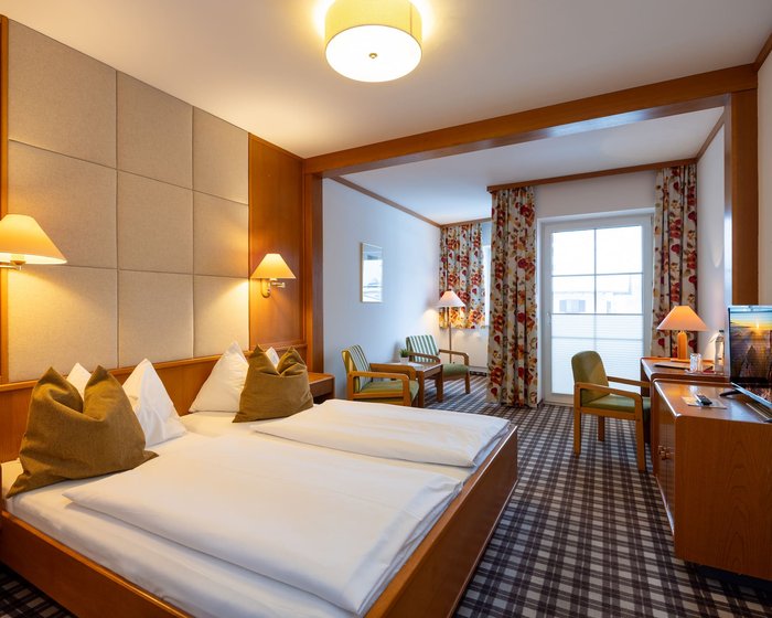 Cozily furnished double room at Hotel zum Mohren with a sitting area, desk, and balcony.