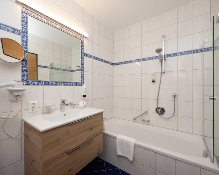 Badezimmer im Familienzimmer Comfort mit Badewanne und Holzwaschtisch.